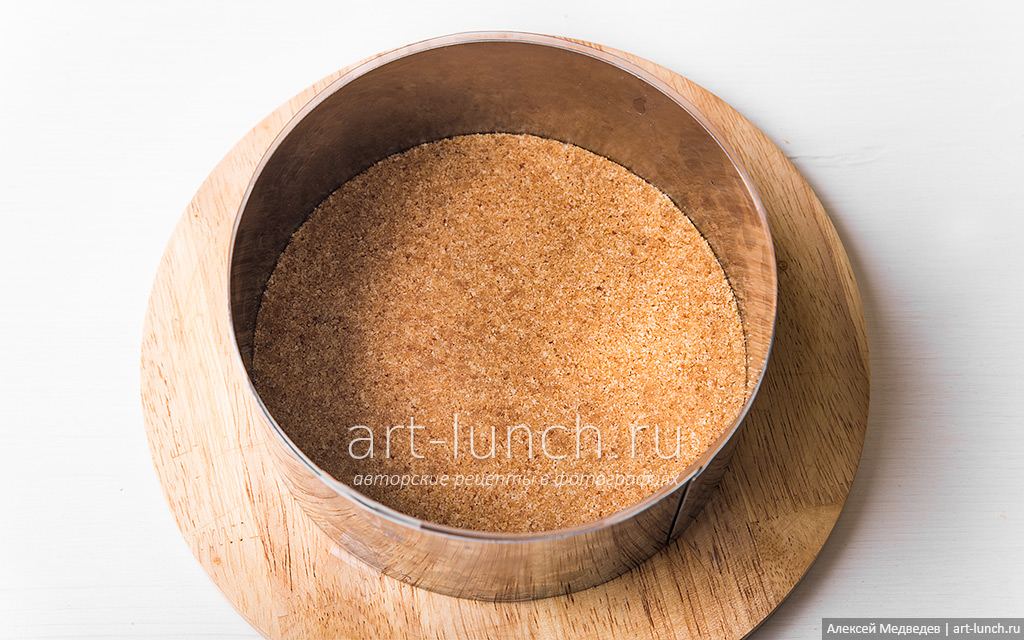 Фото 4-го шага рецепта: Лимонный чизкейк без выпечки В форму высыпаем песочную крошку, равномерно распределяем