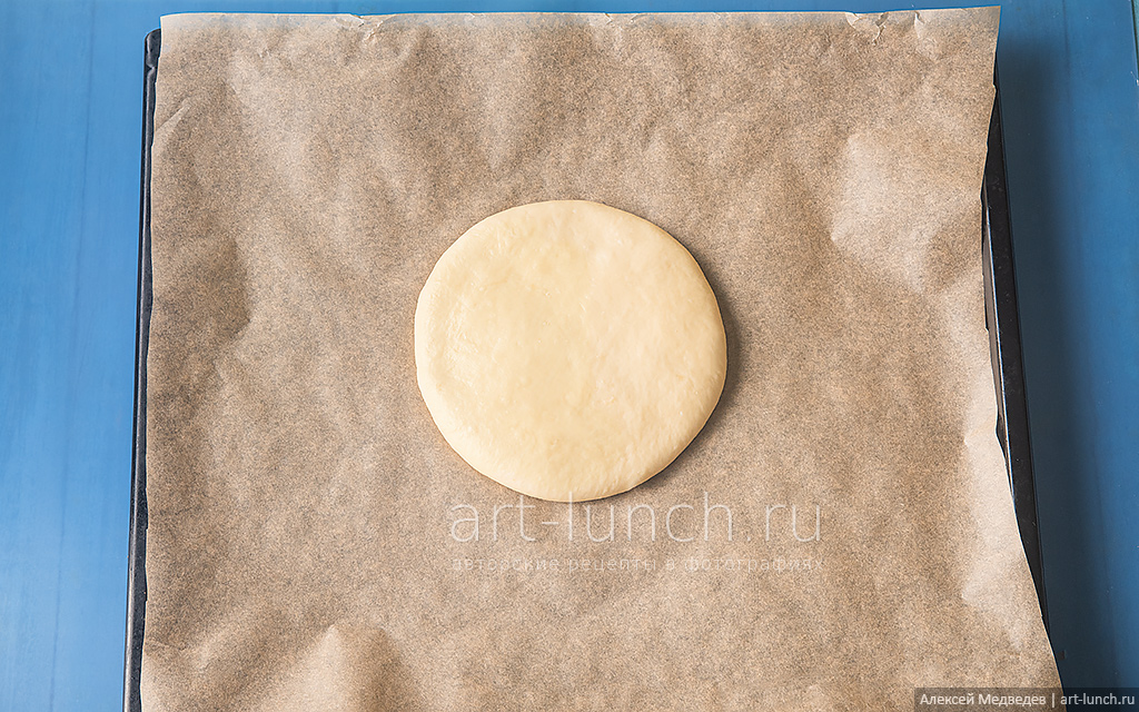 Кладём на неё шар теста и слегка приминаем его ладонями